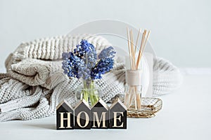 Composition with muscari flowers and aroma sticks and the decorative word home