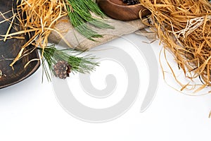 A composition of natural elements with space for text. Spruce branches, burlap, pine cones on a white background.