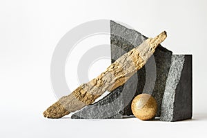 Composition with nature elements - stones, golden sphere and wooden log on white background