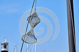 Composition is navy consisting of a rope, masts and fishing net against a blue sky. Background consept