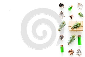 Composition with New Year gift wrapped in craft paper and decorted with pine sprout near pine sprigs, cones, spruce