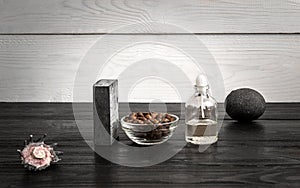 Composition of oil bottles and soap on black wooden background