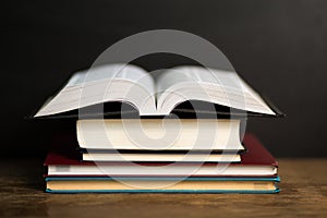 Composition with old hardback books, diary on wooden deck table and dark background. Back to school