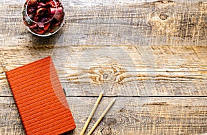 Composition of orange notebook with flower sachets on wooden tab