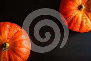 Composition of orange pumpkins on a black wooden background with copy space. Autumn harvest, Thanksgiving day - two pumpkins