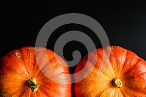 Composition of orange pumpkins on a black wooden background with copy space. Autumn harvest, Thanksgiving day - two pumpkins