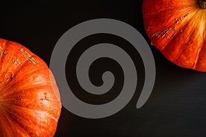 Composition of orange pumpkins on a black wooden background with copy space. Autumn harvest, Thanksgiving day - two pumpkins