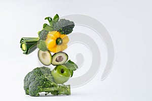 .Composition from organic green raw vegetables and fruits zucchini, cucumber, avocado, apple, on a white background. Healthy