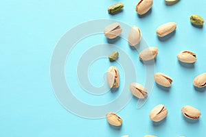 Composition with organic pistachio nuts on color background, flat lay.