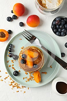 Composition pancakes and fruits on white background, top view