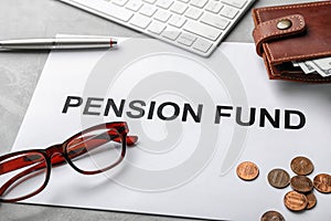 Composition of paper with words PENSION FUND, glasses and money