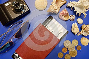 Composition from passport with boarding pass, compact camera, sunglasses, sea shells and foreign coins