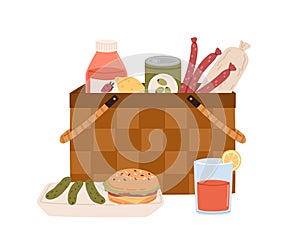 Composition of picnic basket with junk food and drink sausages, burger, pickles, bottle of juice or lemonade. Hamper