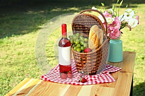 Composition with picnic basket on table