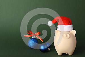 Composition with piggy bank and Christmas decor on color background.