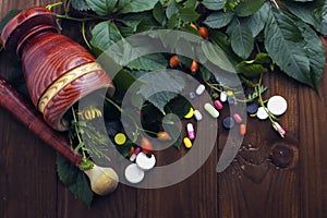 Composition with pills and herbs on wooden background
