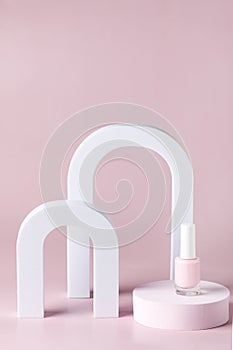 Composition from Pink nail polish bottle on the podium Pink Bright background Festive Cosmetic Concept Minimal Vertical