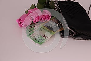 Composition with a pink roses bouquet, clutch, and cash