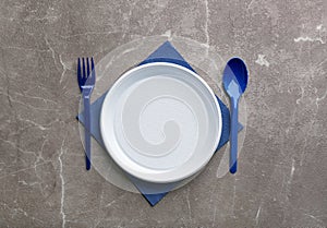 Composition with plastic dishware on grey background