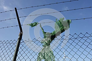 Composition of plastic, metal fence and a wind turbine