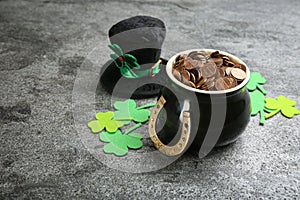 Composition with pot of gold coins and clover leaves on stone table. St. Patrick`s Day celebration