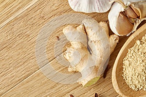 Composition of powder spices on spoon and different sorts of spicies on wooden table background, selective focus