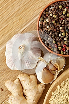Composition of powder spices on spoon and different sorts of spicies on wooden table background, selective focus