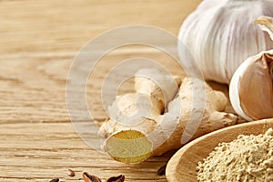 Composition of powder spices on spoon and different sorts of spicies on wooden table background, selective focus