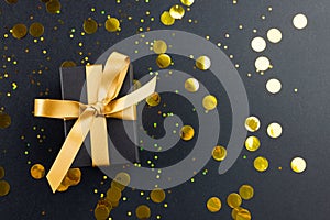 Composition of present with gold ribbon and spots on gray background