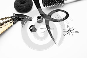 Composition with professional hairdresser\'s supplies and strand on white background