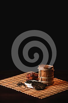 The composition of puer tea with golden toad on a bamboo mat.