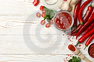 Composition with red hot sauce and ingredients on background