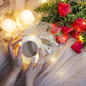 Composition: red roses with boxwood, garlands, candles, star and cup coffee tea