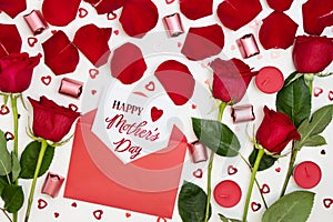 Composition of red roses, chocolates, sequins hearts, envelopes, candles, inscription Happy Mother's Day.