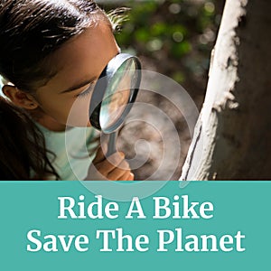 Composition of ride a bike save the planet text over biracial girl with magnifying glass by tree