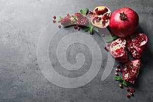 Composition with ripe pomegranates and space for text on grey background photo