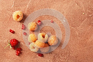 Composition of ripe yellow raspberries on a marble