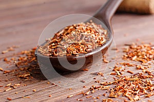Composition of Rooibos tea is located on a ceramic spoon. Macro