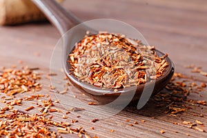 Composition of Rooibos tea is located on a ceramic spoon. Macro