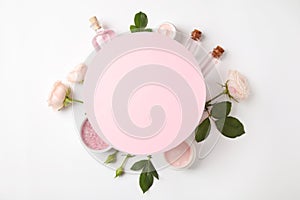 Composition with rose essential oil and blank card on white background. Space for text