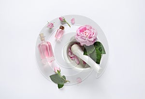 Composition with rose essential oil and flowers, top view