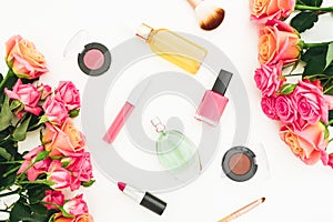 Composition with rose flowers, buds, green leaves and feminine cosmetics on white background. Flat lay, top view. Spring backgroun