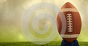 Composition of rugby ball on pitch with copy space with spots of light on yellow background
