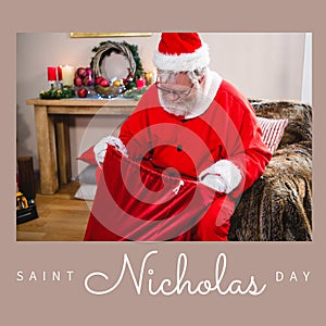 Composition of saint nicholas day text over santa claus holding red sack with presents