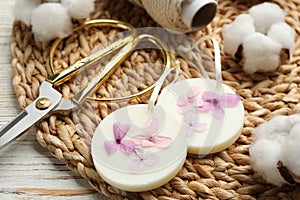 Composition with scented sachets, scissors and flowers on white wooden table