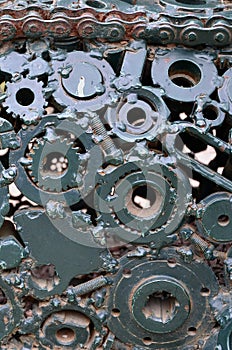 A composition of a set of gears and car parts that are welded to each other and painted green. Grunge steampunk textur