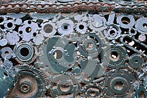 A composition of a set of gears and car parts that are welded to each other and painted green. Grunge steampunk textur