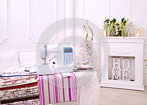 Composition from a sewing machine. Mannequin, flowers on a retro table and threads. Sewing supplies and composition with