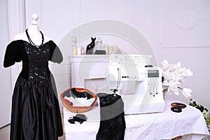 Composition from a sewing machine. Mannequin, flowers on a retro table and threads. Sewing supplies and composition with