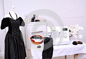 Composition from a sewing machine. Mannequin, flowers on a retro table and threads. Sewing supplies and composition with